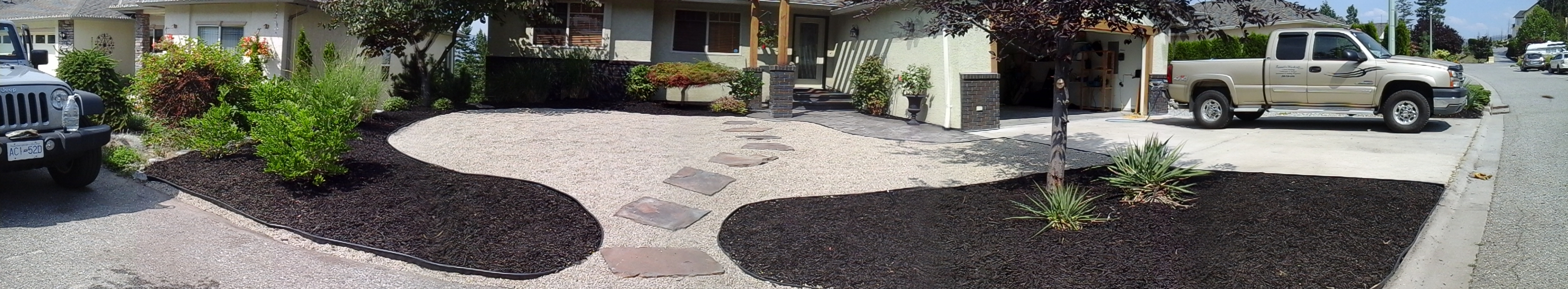 front yard newly landscaped with bark mulch, trees and shrubs